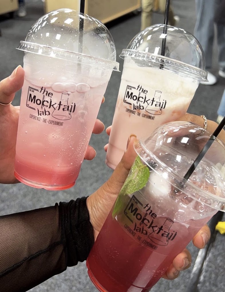 Three branded Mocktail Lab cups cheersing together