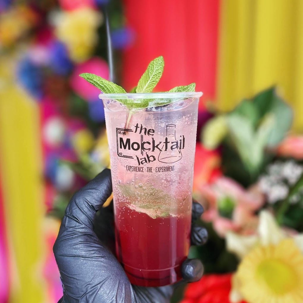 Guest holding a branded Mocktail Lab cup at an event