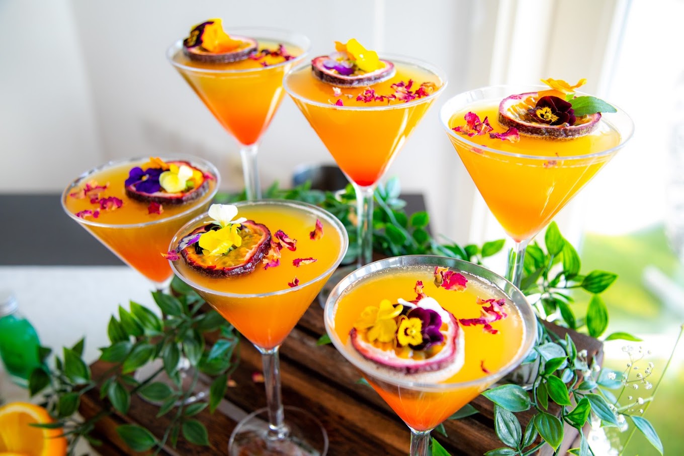Passionfruit mocktail martinis garnished with edible flowers and rose petals